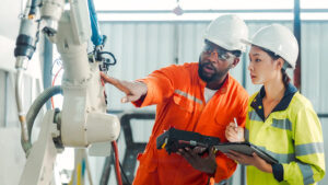 Two workers examine a piece of equipment