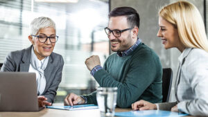  A female financial professional meets with her clients to discuss 401(k) rollover rules and what to do with their abandoned retirement accounts.