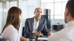 A group of colleagues sitting around a table discussing business.