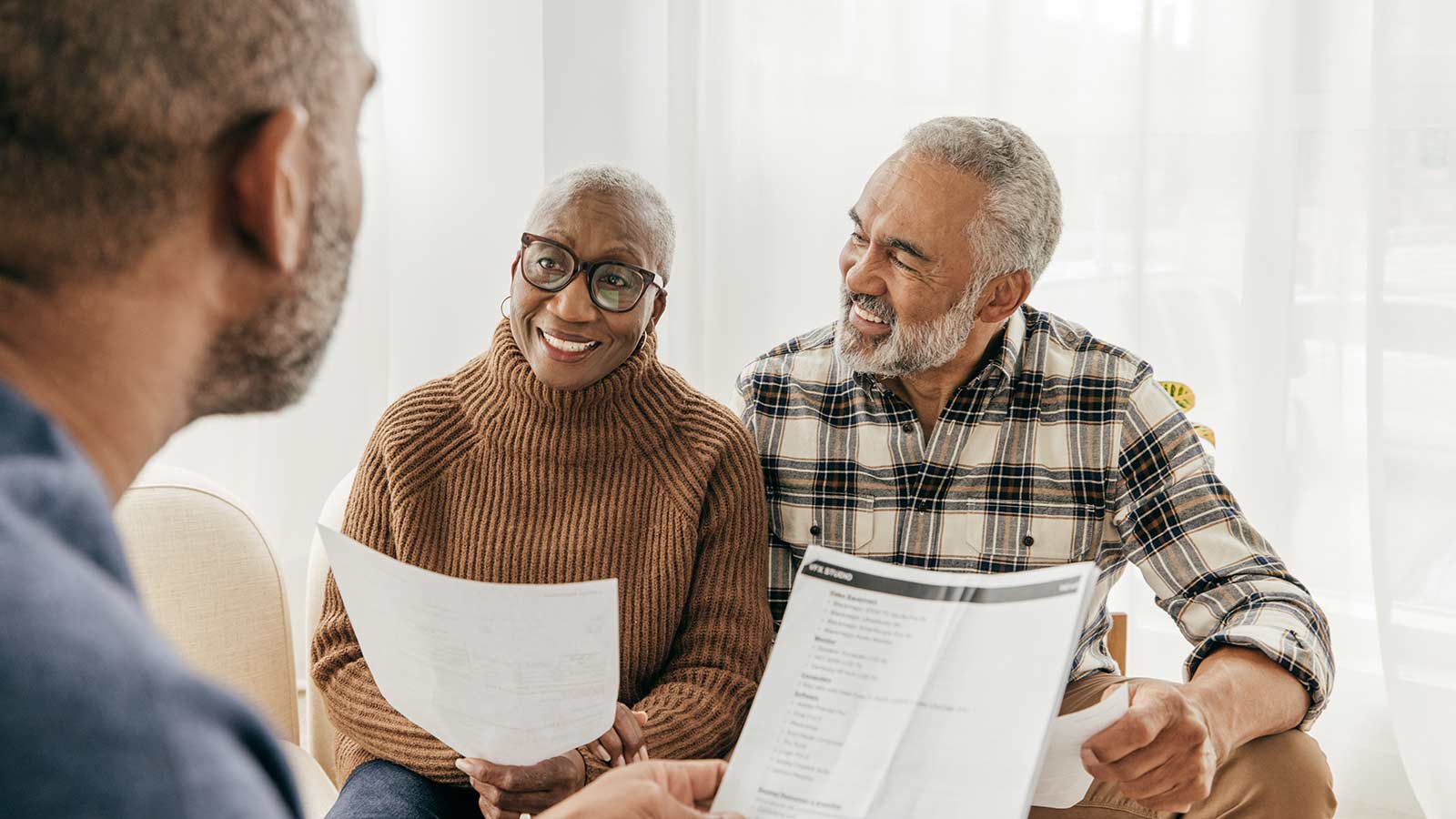 Senior couple talking to their agent about dental plans.