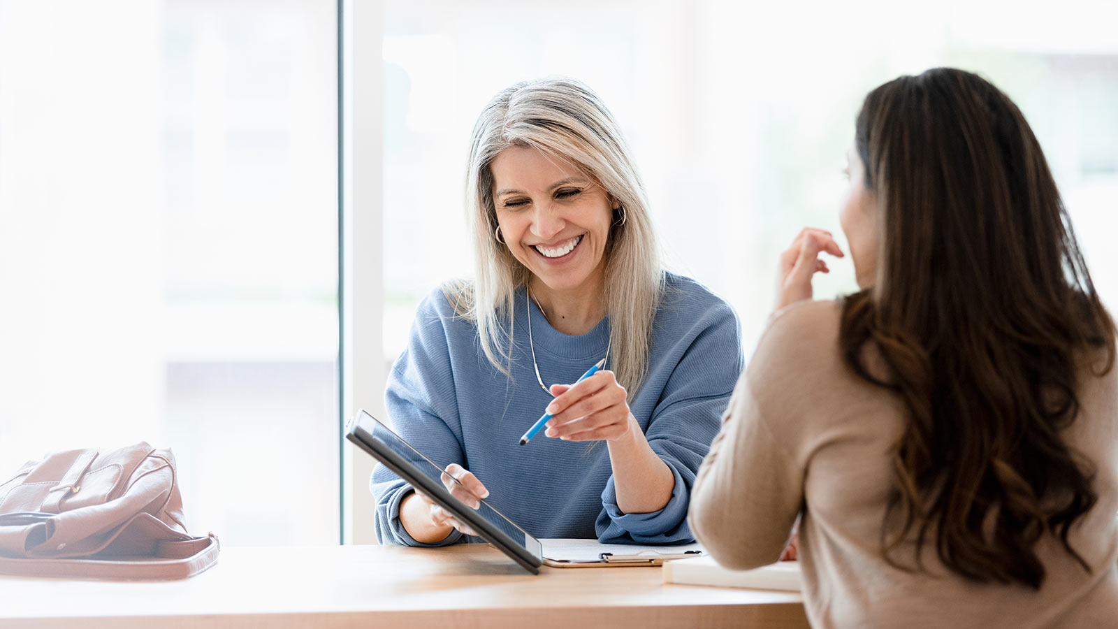 lady helping client at a table talking about finances.