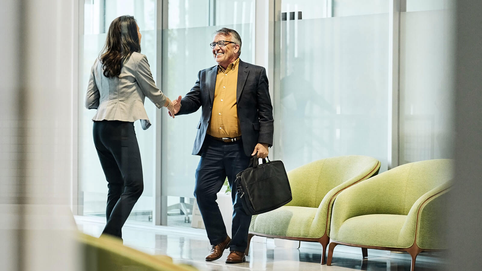 A financial professional meets with a plan sponsor client in her office to review their retirement plan offerings.