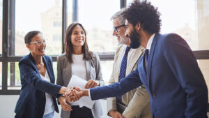 Small group of business professionals shaking hands.