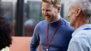 A financial professional in his 40s networks with his peers at a professional development conference.