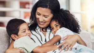 Mom hugging small children on couch