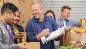 A nonprofit organization holds a volunteer event to pack boxes for underserved families.