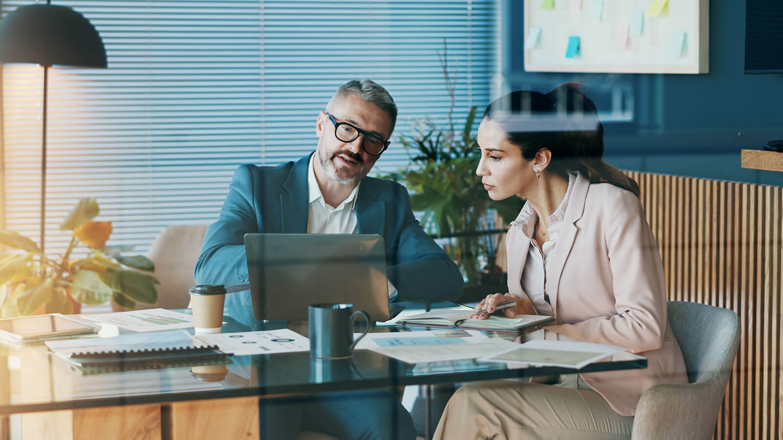 A business owner meets with her financial professional to go over updated SECURE Act 2.0 rules for her retirement plan.